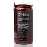 Raw Honey Project Cacao Honey jar with back label describing the brand’s raw and unpasteurized honey process. Text explains the honey is warmed only below 105°F to preserve enzymes, pollen, and antioxidants, and includes a founder message signed by Kevin Carbone.