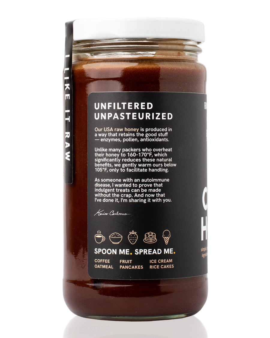 Side panel of Raw Honey Project Cacao Honey jar with a black label. Text reads 