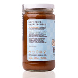 Side panel of Raw Honey Project Cinnamon Bun Honey jar. Text reads "Unfiltered, Unpasteurized" with a founder's note and serving icons for coffee, oatmeal, fruit, pancakes, and ice cream.